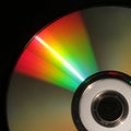 Isolated vertical closeup of the light reflecting off a compact disc in front of a black background Royalty Free Stock Photo