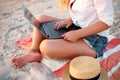 Isolated view of authentic woman working with laptop on sea shore. Freelancer girl telecommuting with team on tropical