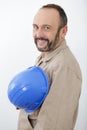 isolated view builder holding hardhat across chest