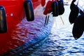 Isolated view on red boat side with black fenders and reflection of sea in the wall of luxury yacht - Marine de Cogolin, France Royalty Free Stock Photo