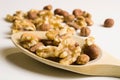 Isolated walnuts and almonds in macro view on a wooden spoon