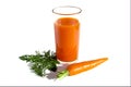 On an isolated white background, a glass of fresh tasty carrot juice and a whole carrot with leaves. Royalty Free Stock Photo