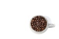 Transparent cup full of roasted coffee beans on a white background, top view, close-up. Royalty Free Stock Photo