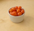 Isolated bowl of cherry tomatoes on a wooden background