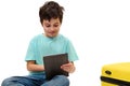 Isolated on white handsome teenage traveler boy using digital tablet, browsing websites, checking flight information