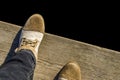 Feet in shoes on wooden background