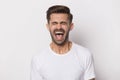 Angry stressed outraged hysterical millennial guy screaming. Royalty Free Stock Photo