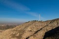 Isolated wind turbine on top of a hill with semi-desert landscape and a valley in the background Royalty Free Stock Photo