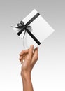 Isolated Woman Hands holding Holiday Present White Box with Dark Black Ribbon on a White Background Royalty Free Stock Photo