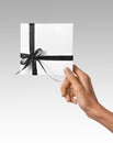 Isolated Woman Hands holding Holiday Present White Box with Dark Black Ribbon on a White Background Royalty Free Stock Photo