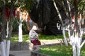 Isolated woman with white hat is sitting in the park