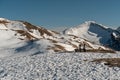 An isolated Wooden Bench in the Middle of Snow-covered Mountains Royalty Free Stock Photo