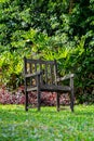 Isolated wooden chair on grass lawn with beautiful garden background Royalty Free Stock Photo