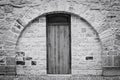 Isolated wooden door in a brick wall with a rounded arch Prague, Czech Republic