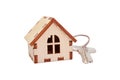 Isolated wooden house with key on white background, concept for selling houses, with copyspace Royalty Free Stock Photo