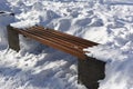 Isolated wooden park bench covered with snow after a snowfall. Close up. Wintertime. Copy space. Background. Royalty Free Stock Photo