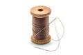 Isolated wooden spool of brown thread