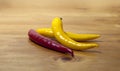 Isolated yellow and red hot chilli peppers for ingredient of spicy meal or salad on wooden natural background