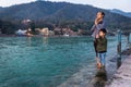  young man and kid prying the holy ganges river at river bank from flat angle
