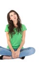 Isolated young pensive woman sitting with crossed legs. Royalty Free Stock Photo