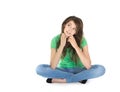 Isolated young reflective woman sitting with crossed legs.