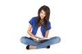 Isolated young woman with open book sitting with crossed legs.