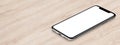 Isometric black smartphone similar to iPhone X mockup lies on wooden office desk banner with copy space