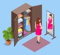 Isometric girl stands near an open wardrobe and chooses clothes. Woman tries on clothes and looks in the mirror