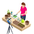 Isometric video blogger planting flower, gardening and housework. Woman or blogger planting pot flowers with camera