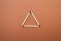 Isosceles triangle on a bright background. matchstick pyramid on cardboard. Education concept