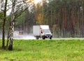 isotherm mini truck transports cargo against the backdrop of a forest in rainy cloudy weather in summer, industry Royalty Free Stock Photo