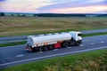 Isothermal Tank truck driving on highway. Oil and Gas Transportation and Logistics. Metal chrome cistern tanker with