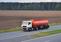 Isothermal Tank truck driving on highway. Oil and Gas Transportation and Logistics. Metal chrome cistern tanker with