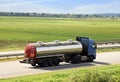 Isothermal Tank truck driving on highway. Oil and Gas Transportation and Logistics. Metal chrome cistern tanker with