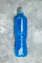 Isotonic blue energy drink. Vertical photo with blue water, sport beverage. Concrete background