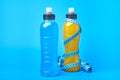 Isotonic energy orange yellow and blue sport drink in plastic bottles and measure tape