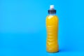 Isotonic energy yellow sport drink in plastic bottle on blue background Royalty Free Stock Photo