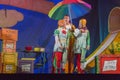 Israel, Beer-Sheva, Negev -Two actresses and actors of children's theater on the stage with a large umbrella, 2015