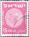 Israel circa 1949: A post stamp printed in Israel showing a coin with a bunch of grapes