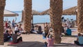 A group of people of different ages, from different countries doing yoga on the Red Sea beach