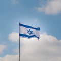 Israel flag on blue sky and white clouds background.