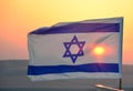 Israel flag with Star of David against sunset