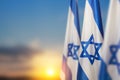 Israel flags with a star of David over cloudy sky background on sunset. Banner with place for text. Royalty Free Stock Photo