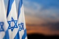 Israel flags with a star of David over cloudy sky background on sunset. Banner with place for text. Royalty Free Stock Photo