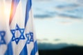 Israel flags with a star of David over cloudy sky background on sunset. Banner with place for text. Royalty Free Stock Photo