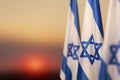 Israel flags with a star of David over cloudy sky background on sunset. Banner with place for text. Royalty Free Stock Photo