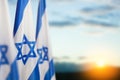 Israel flags with a star of David over cloudy sky background on sunset. Banner with place for text. Royalty Free Stock Photo