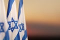 Israel flags with a star of David over cloudy sky background on sunset. Banner with place for text. Royalty Free Stock Photo