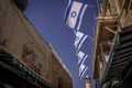 The Israel flags are on the streets of Jerusalem old city with the mosque minaret in the background. Royalty Free Stock Photo