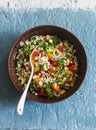 Israeli cous cous ptitim vegetables tabbouleh salad on a blue background, top view. Vegetarian food